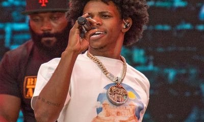 rapper a boogie wit da hoodie sings into microphone on stage