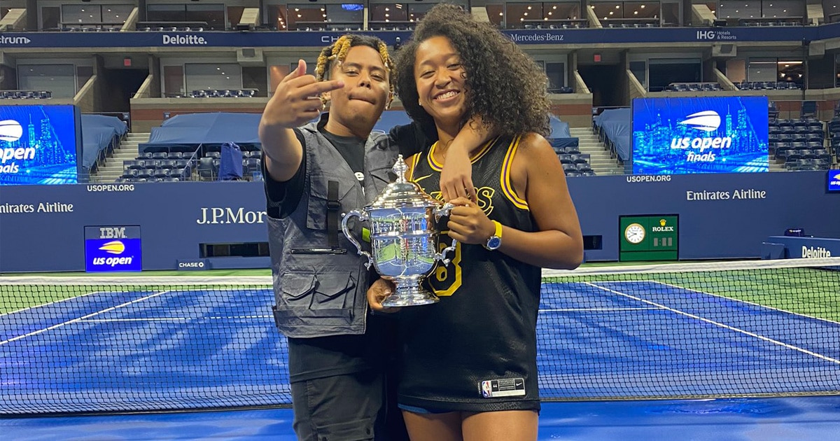 rapper cordae flipping the bird and holding arm around girlfriend naomi osaka on tennis court