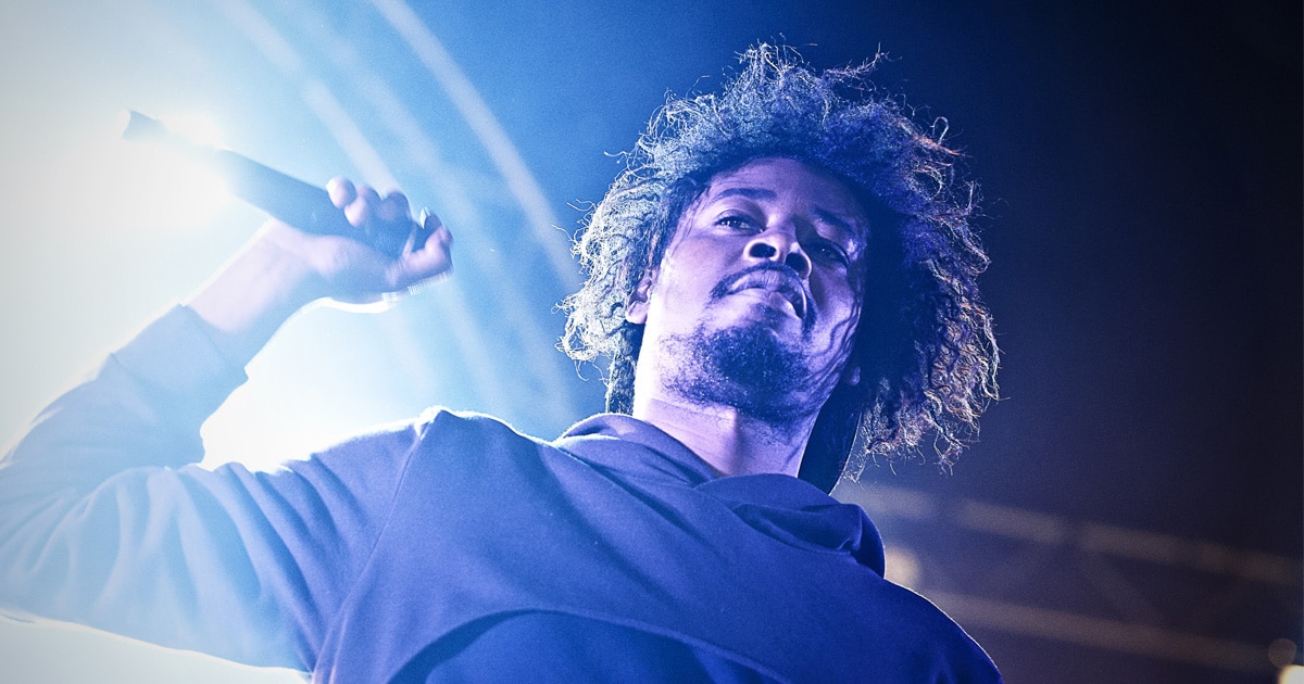rapper danny brown holds microphone on stage at 2013 beacons festival