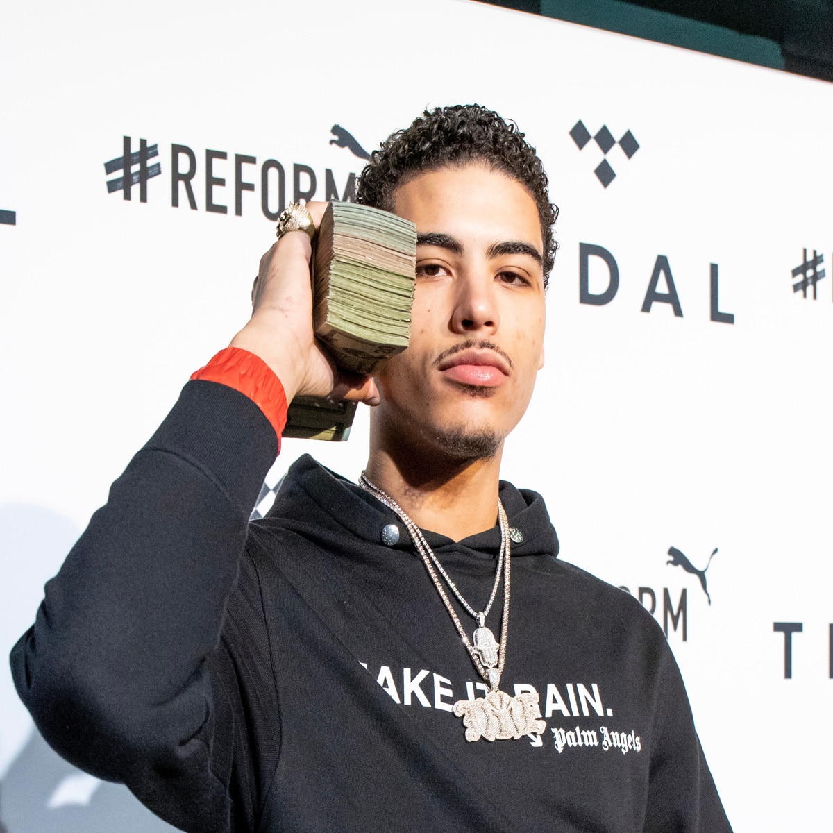 rapper jay critch holds stack of money to ear at tidal x in brooklyn, new york