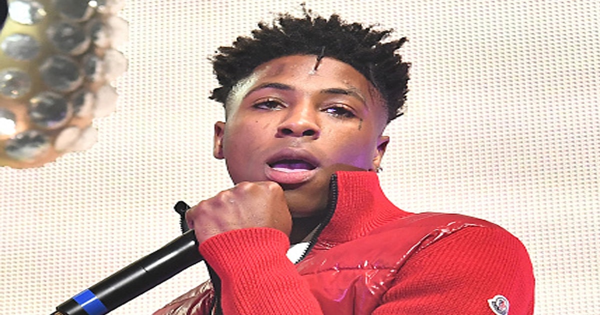 rapper nba youngboy holds microphone at concert