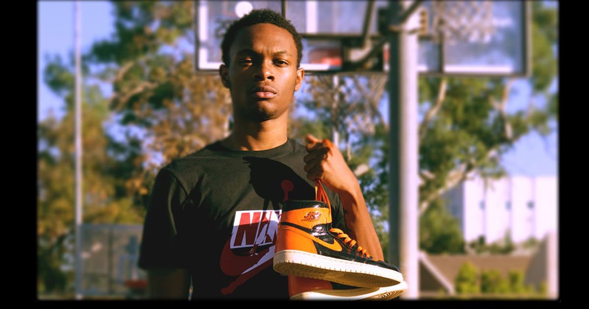 rapper lil eazzyy poses with air jordan 1s on basketball court