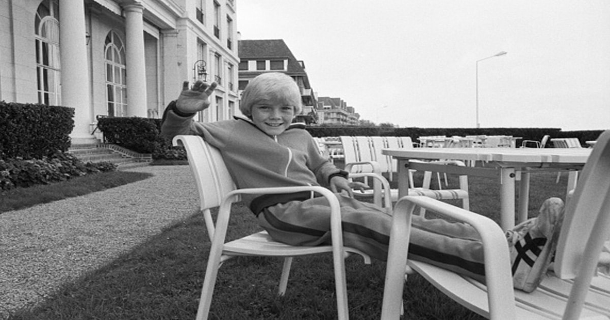 actor ricky schroder poses on chair in black and white