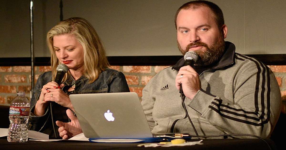 comedian tom segura holds microphone during podcast