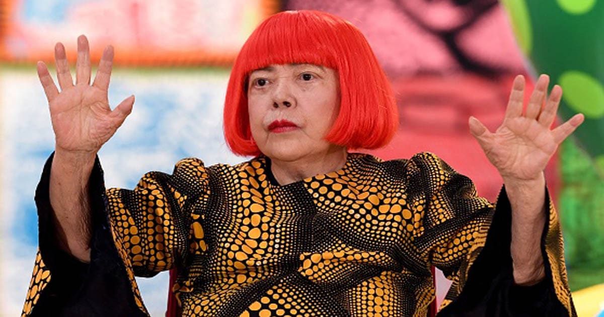 Japanese artist Yayoi Kusama waves at a photo session during a press preview