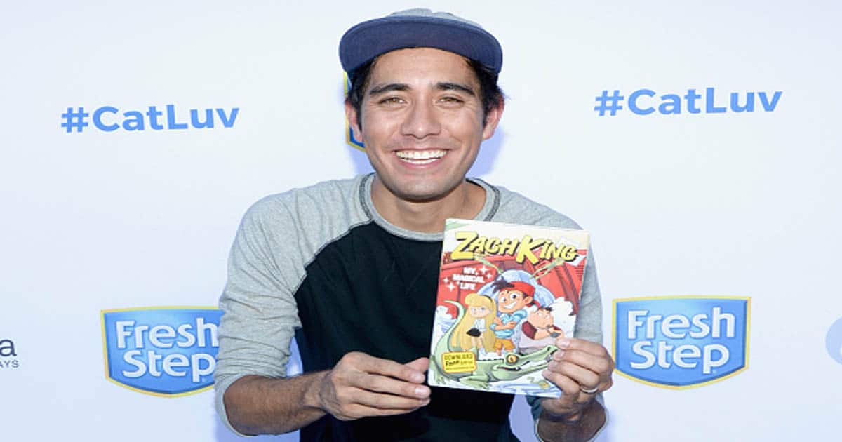 Zach King holds his book 'My Magical Life' at the unveiling of "Cat Luv" Mural 
