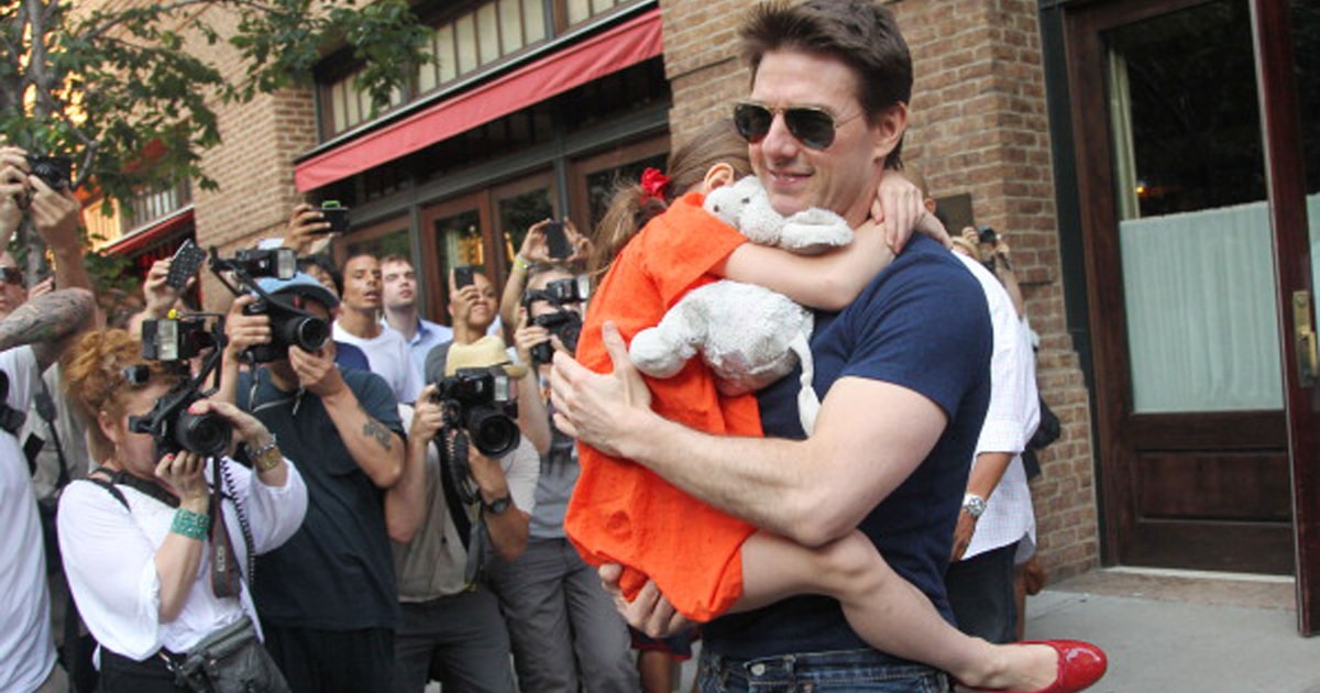 Tom Cruise leaves his hotel carrying daughter Suri for her gymnastics class