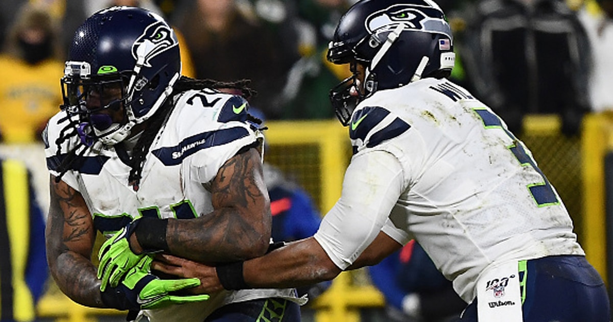 Russell Wilson #3 of the Seattle Seahawks hands the ball off to Marshawn Lynch #24 during the NFC Divisional Playoff game