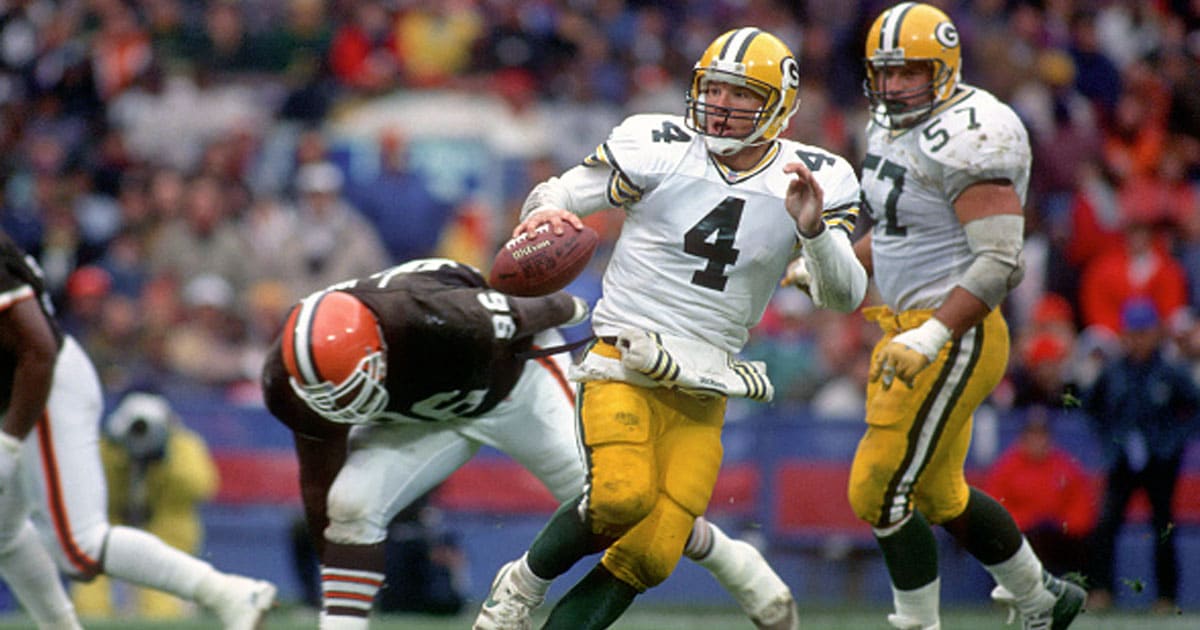 Brett Favre #4 of the Green Bay Packers looks to pass as he scrambles while pursued by defensive lineman James Jones #96 of the Cleveland Browns