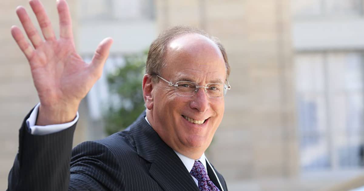 Larry Fink (L) waves as he leaves a meeting about climate action investments with heads of sovereign wealth funds and French President 