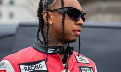 Tyga is seen wearing black red white racing leather jacket & pants, sunglasses outside Givenchy