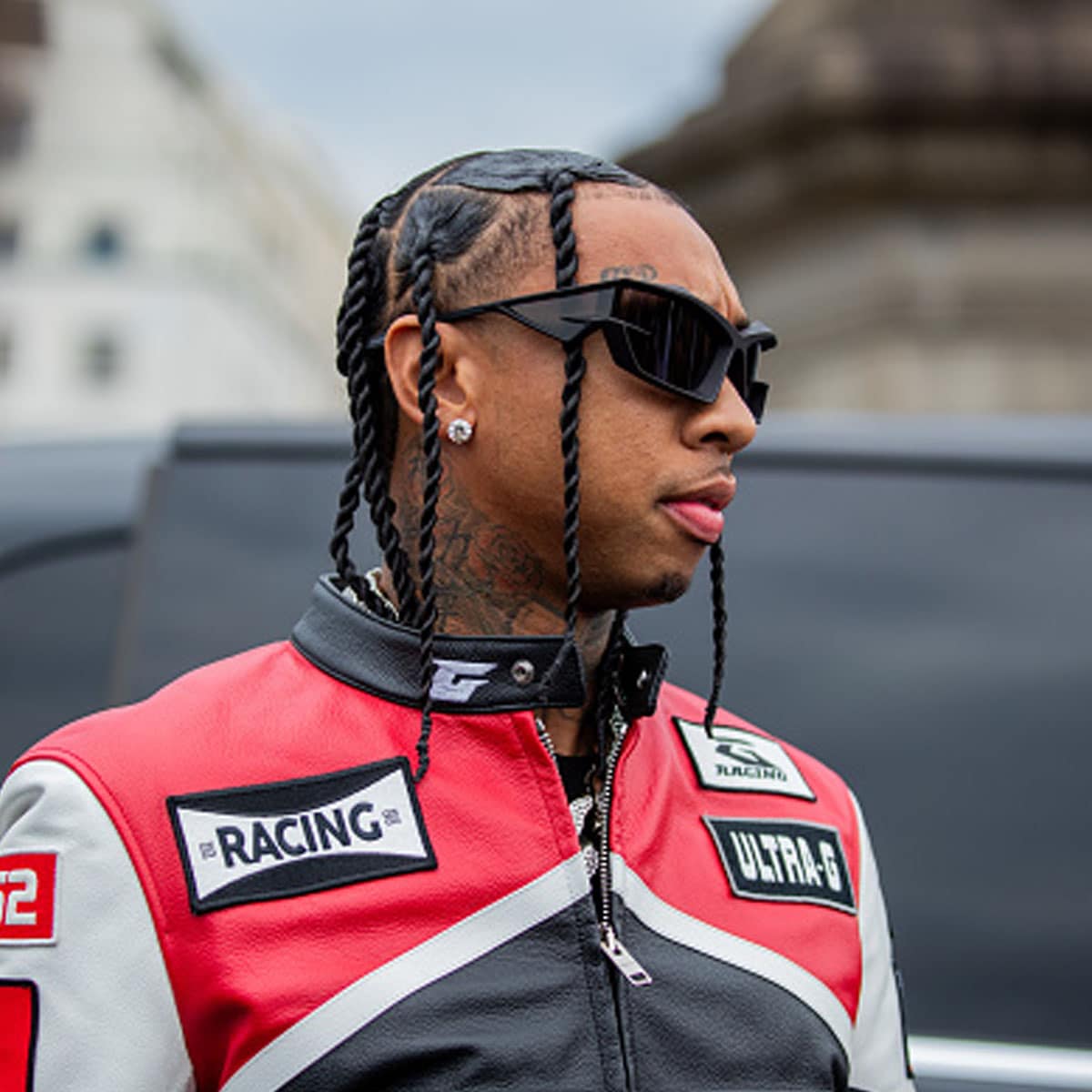 Tyga is seen wearing black red white racing leather jacket & pants, sunglasses outside Givenchy