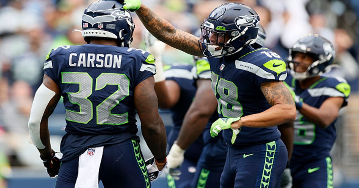Chris Carson #32 and Freddie Swain #18 of the Seattle Seahawks react after a touchdown against the Tennessee Titans